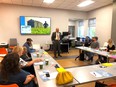 GA Agricultural Wellness Alliance meeting with several people in a classroom listening to a man in a suit up front.