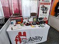 AgrAbility booth at World Dairy Expo with AgrAbility of WI banner in back right and table with AgrAbility materials in front.