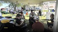 2 men in powered wheelchairs under a tent talking with 3 other people including Dee Jepsen while enjoying icecream