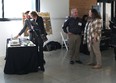 Ed Sheldon on left and Dr. Roger Tormoehlen on right each speaking with a woman near a display table.