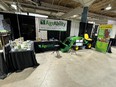 AgrAbility booth with materials on tables and LifeLyfts John Deere tractor with lift at Ft Wayne Farm Show