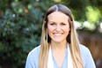Portrait of a young woman - Jesse Coble - smiling at the camera with a natural greenery background