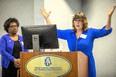 Crystal Cook Marshall with hands raised sharing from behind the podium at the NC Agromedicine Institute's 25th anniversary symposium