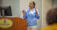 Crystal Cook Marshall with hands raised sharing from behind the podium at the NC Agromedicine Institute's 25th anniversary symposium