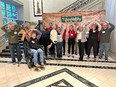 OH AgrAbility staff and farmers with Farm Credit staff holding their hands above their heads next to animatronic bull T-bone at NTW