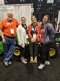 Marty Cotterman on left with 3 women next to him and a small modified JD tractor behind them.
