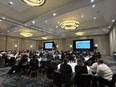 Large group of people sitting at round tables listening to speaker in large ballroom at Atlanta NTW