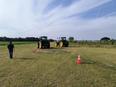 2 tractors in a field where orange & white pylons are arranged for a tractor workshop