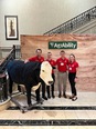 Dr. Dee Jepson's capstone team of 3 men and 1 woman standing next to an animatronic bull at the AgrAbility NTW