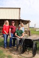 3 women standing behind man on truck lift with wheelchair in front of them