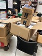 A man standing behind a lot of Amazon boxes in a room.