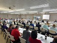 A large room with people seated at long tables at the NRCS diversity training event