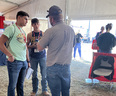 3 men talking in a tent at Husker Harvest Days in NE