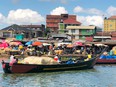 A loaded boat approaching a town on Lake Victoria in Uganda