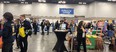Many people in FFA jackets in a large room with various displays