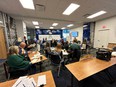 People in a classroom working at long desks