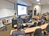 Group of people in a large conference room listening to Kyle Haney of GA AgrAbility present a powerpoint