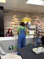 Two people at an AgrAbility booth with Kimber Nicoletti sitting behind the booth table