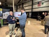 Bill Field talking with a man in front of the AgrAbility booth at the Purdue Fish Fry