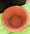 Top view of a clay pot water filter sitting on a green towel