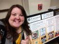 Emily Doosing giving a thumbs-up in front of her Brain Injury Association of MO poster.