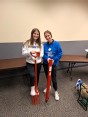 2 female occupational therapy students at Indiana State University each holding a piece of assistive technology used in agriculture