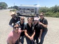 7 people smiling for the camera with a food truck in the background during the cherry harvest outreach