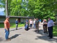 IN advisory team standing outside on a wooded paved road listening to Adam Sweet