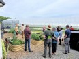 AgVOLS  touring the Sweeter Days Farm - standing outside a large hoop house next to some raised bed gardens