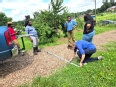 Mary Keeter measuring a spot on the ground with 4 African Americans looking on.