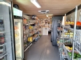 Inside of the Mobile Grocery Store showing shelves and refrigerators on each side with a center isle and a sales counter at the end