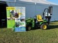 The LifeLyfts tractor and lift outside a white tent with the LifeLyfts and AgrAbility banners in front of it