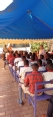Picture of African students under a blue canopy learning about health and safety issues.