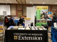Missouri AgrAbility booth table and pop-up banner in an exhibition hall.