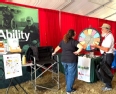 Emily Jacobson sharing with a beaded man at the NE AgrAbility booth.