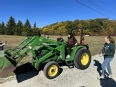 OT students outdoors learning to drive a John Deere tractor at AT Expo