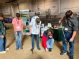 5 youths trying assistive technology in front of a NE AgrAbility booth