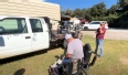 Robertson County farmer in a wheelchair next to a flat-bed truck with another wheelchair on it