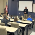 Veteran Matthew Harvey sharing his story with OT students in a large classroom at ISU.