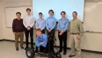 6 young men and Ned Stoller forming the kneeler cart capstone group with the kneeler cart in front of them.