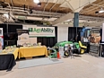 AgrAbility booth with 2 tables and the LifeLyfts tractor with seat-lift at the Fort Wayne Farm Show.