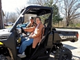 Farmer recipients of some new assistive technology sitting in a new Polaris Ranger.