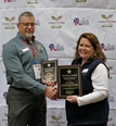 Eileen Legault presenting A VOL Star award to a man.