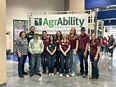 Lisa Becker on the left with Vincennes University ag students and staff in front of an AgrAbility banner.