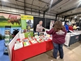Steve Etheridge at the IN AgrAbility booth handing some AgrAbility material to a woman at the N IN Grazing Conference