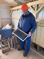 A man working with bee hives in a room.