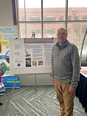 Kirk Funkenbusch standing in front of poster at NTW